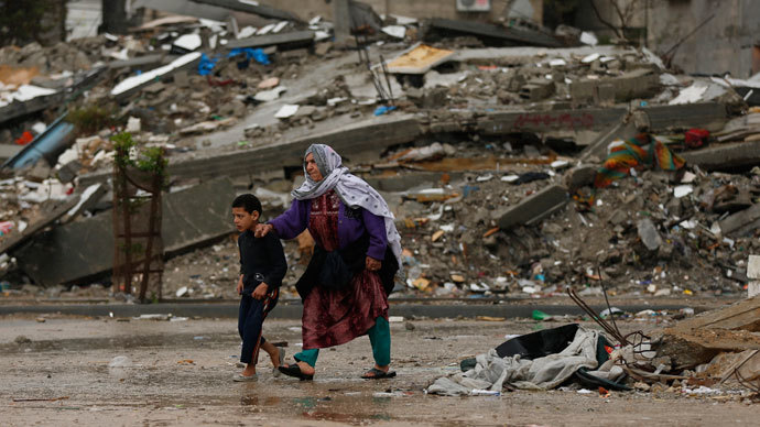 Palestinians walk near houses destroyed in a past Israeli air strike, on a windy winter day in Jabalya in the northern Gaza Strip.(Reuters / Mohammed Salem)