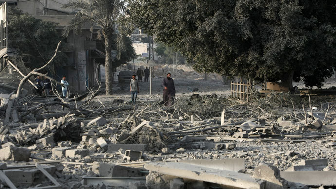 Palestinian men walk amidst debris at the destroyed compound of the internal security ministry in Gaza City after it was targeted by an Israeli air strike overnight.(AFP Photo / Mahmud Hams)