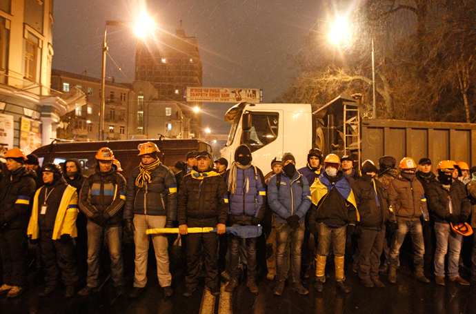 People wear helmets and masks as they line up during a rally organized by supporters of EU integration in central Kiev, December 8, 2013. (Reuters / Vasily Fedosenko) 
