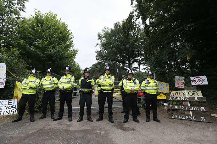 Police officers guard a gate on the edge of a site run by Cuadrilla Resources, near Balcombe in southern England August 16, 2013 (Reuters / Stefan Wermuth)