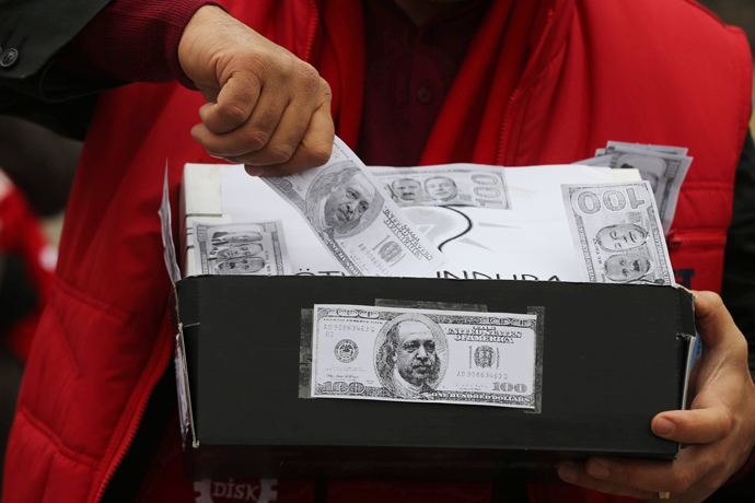 A demonstrator carries a shoe box, a symbol of the corruption scandal after police found $4.5 million secreted in shoe boxes in the home of the chief executive of Turkish state-owned Halkbank, during an anti-corruption protest in Ankara on January 11, 2014 (AFP Photo / Adem Altan)