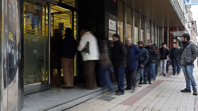 A long exposure photo shows people waiting outside a government employment office in Burgos on February 4, 2013. (AFP Photo / Cesar Manso)