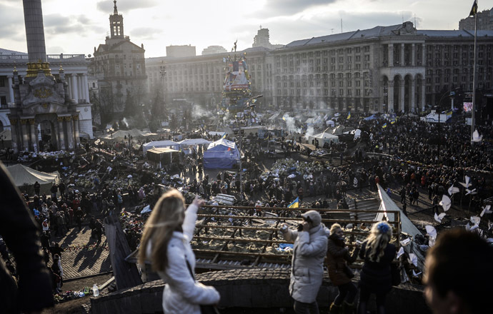 People watch Kiev's Independence Square from a balcony on February 24, 2014. (AFP Photo)