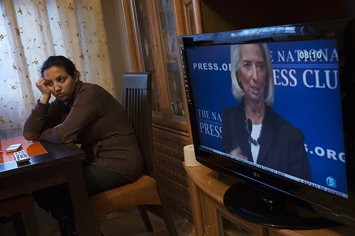 IMF Chief Christine Lagarde is seen on TV as Eva Borja Jimenez waits for the judicial commission to carry out her eviction in Madrid (Reuters / Susana Vera)