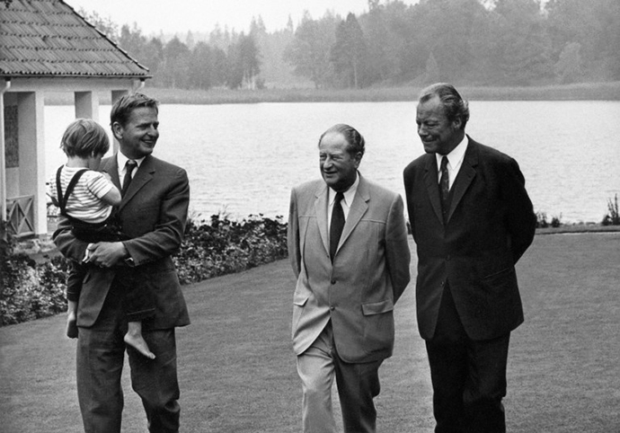 Swedish Prime Minister, Olof Palme (L), carries his child, walking in his Harpsund's property in Sweden, with Bruno Kreisky, Austrian chancellor (C) and his West German counterpart Willy Brandt (R), 04 August 1971. (AFP Photo)