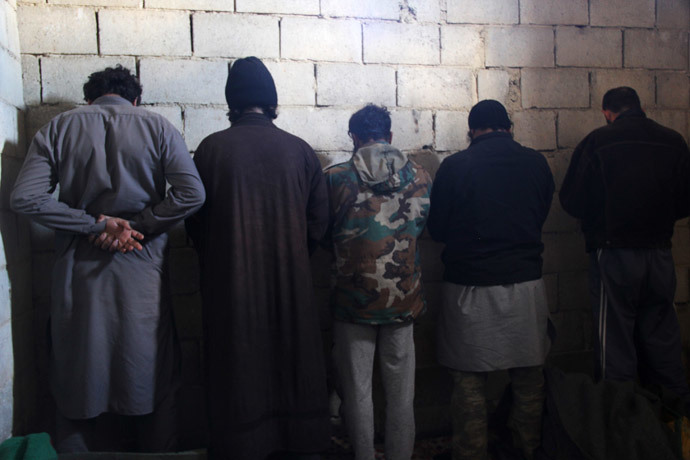 Fighters from the Islamic State in Iraq and the Levant (ISIL) are seen detained by the Free Syrian Army fighters (unseen) after the FSA captured their base in the countryside of Hama January 9, 2014. (Reuters / Omran Morad)