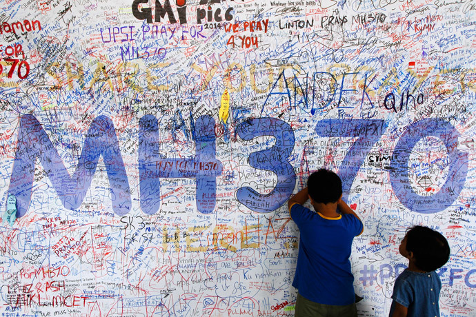 Children write well-wishes on a banner for the passengers and crew of the missing Malaysia Airlines Flight MH370 at a viewing gallery in Kuala Lumpur International Airport March 19, 2014.(Reuters / Edgar Su)
