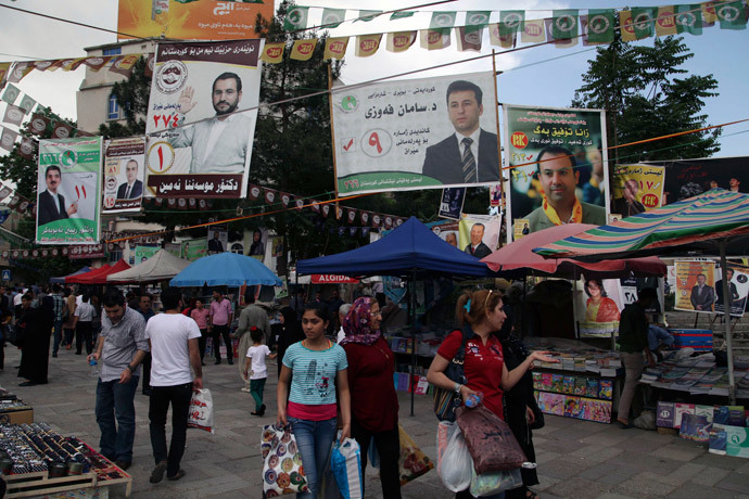 People walk past campaign posters for Iraq's parliamentary elections in Sulaimaniya April 28, 2014. Picture taken April 28, 2014. (Reuters / Yahya Ahmad) 