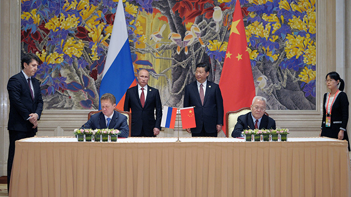 China's President Xi Jinping (back R) and Russia's President Vladimir Putin (back L) attend an agreement signing ceremony in Shanghai on May 21, 2014, with Gazprom CEO Alexei Miller (front L) and Chinese state energy giant CNPC Chairman Zhou Jiping (front R) signing an agreement. (AFP Photo / Alexey Druzhinin)