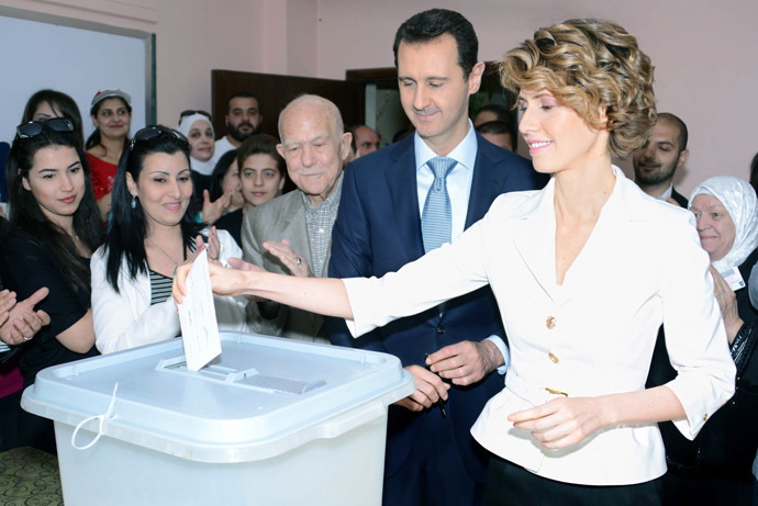 A handout picture released by the official Syrian Arab News Agency (SANA) shows Syrian President Bashar al-Assad (C) watching on as his wife Asma casts her vote at a polling station in Maliki, a residential area in the centre of the capital Damascus, in the country's presidential elections on June 3, 2014, which are expected to give Assad a sweeping win over two little-known challengers, state television reported. (AFP/SANA)