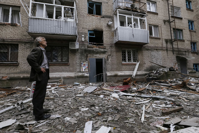 A man looks at a residential building, where he resides, which was damaged by what locals say was overnight shelling by Ukrainian forces, in the eastern Ukrainian town of Slaviansk June 12, 2014. (Reuters/Gleb Garanich)