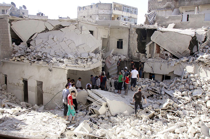 Syrian residents search the rubble for survivors following a reported air strike by government forces on June 18, 2014 in the northern city of Aleppo. (AFP Photo / Baraa Al-Halabi)