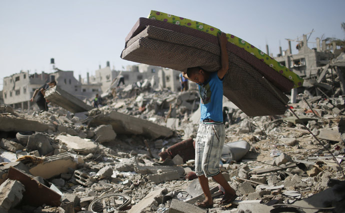 A Palestinian carries mattresses from his destroyed house in the Shejaia neighborhood, which witnesses said was heavily hit by Israeli shelling and air strikes during Israeli offensive, in the east of Gaza City August 1, 2014. (Reuters)