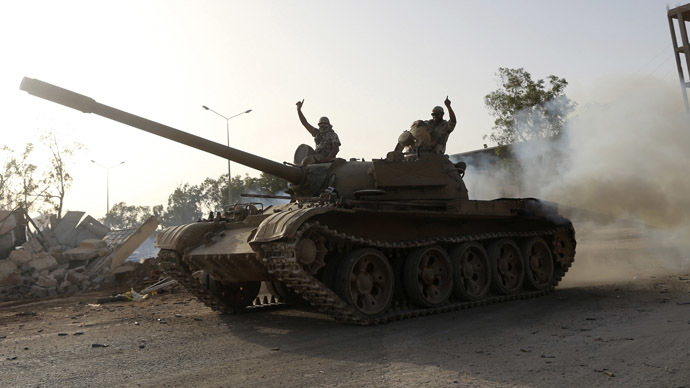 Fighters from the Benghazi Shura Council, which includes former rebels and militants from al Qaeda-linked Ansar al-Sharia, gesture on top of a tank next to the camp of the special forces in Benghazi July 30, 2014. (Reuters)