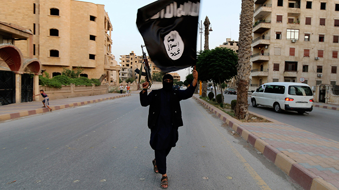 A member loyal to the Islamic State in Iraq and the Levant (ISIL) waves an ISIL flag in Raqqa June 29, 2014 (Reuters / Stringer)