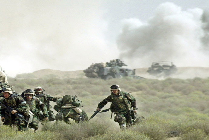 Marines of the U.S. Marine Expeditionary Unit (MEU) Fox Company "Raiders" take cover from Iraqi fire as British artillery rounds explode behind during the early stage of the push into southern Iraq to take control of the main port of Umm Qasr on March 21, 2003. (Reuters)