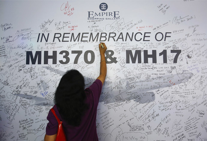 A woman writes a message on a dedication board for the victims of the downed Malaysia Airlines Flight MH17 airliner and the missing Flight MH370, in Subang Jaya outside Kuala Lumpur July 23, 2014. (Reuters)
