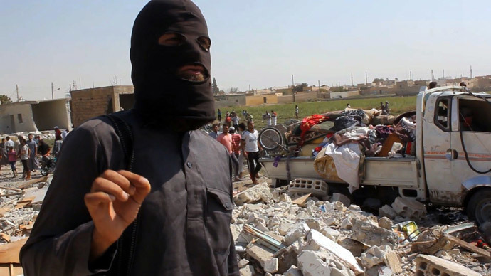 An image grab taken from an AFPTV video on September 16, 2014 shows a jihadist from the Islamic State (IS) group standing on the rubble of houses after a Syrian warplane was reportedly shot down by IS militants over the Syrian town of Raqa (AFP Photo / Str)