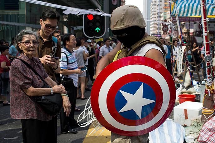 A protester of the Occupy Central movement carries a shield from the 'Captain America' comic book series as he stands on a main road at the Mong Kok shopping district in Hong Kong October 6, 2014 (Reuters / Tyrone Siu)