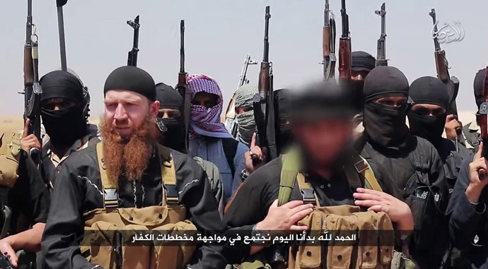 An image made available by Jihadist media outlet al-Itisam Media on June 29, 2014, allegedly shows members of the IS (Islamic state) including military leader and Georgian native, Abu Omar al-Shishani (Tarkhan Batirashvili) (C-L) and ISIL sheikh Abu Mohammed al-Adnani (C-R), whose picture was blurred from the source to protect his identity, speaking at an unknown location between the Iraqi Nineveh province and the Syrian town of Al-Hasakah. (AFP Photo / HO / Al-Itisam Media)