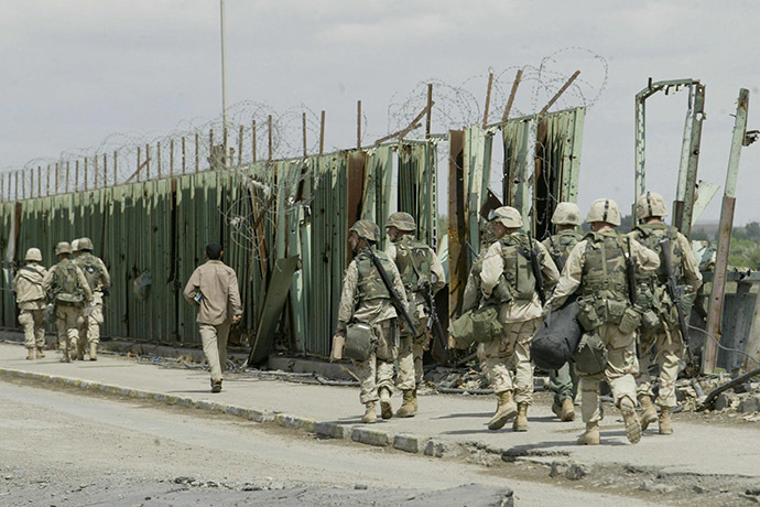 US troops cross 17 April 2003 a damaged bridge in the northern Iraqi city of Tikrit, the hometown of Iraq's toppled leader Saddam Hussein. (AFP Photo/Joseph Barrak)