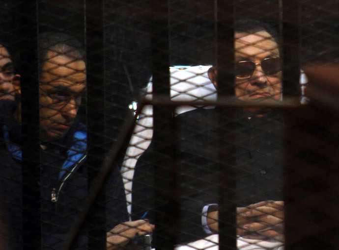 Egypt's former president Hosni Mubarak (R) and his son Gamal sit behind bars during a court hearing on November 29, 2014 in the capital Cairo. (AFP Photo / Str)