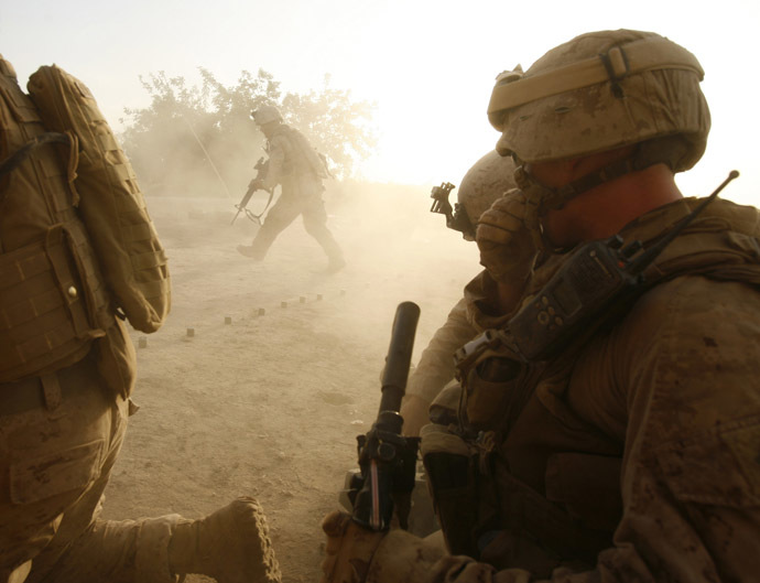 U.S. Marines from Lima company 3rd Battalion 6th Marine Regiment take shelter from the back blast as a Marine fires a law rocket while under fire from Taliban at their patrol base roof in the area of Karez-e-Sayyidi, in Helmand province, April 5, 2010. (Reuters/Asmaa Waguih)