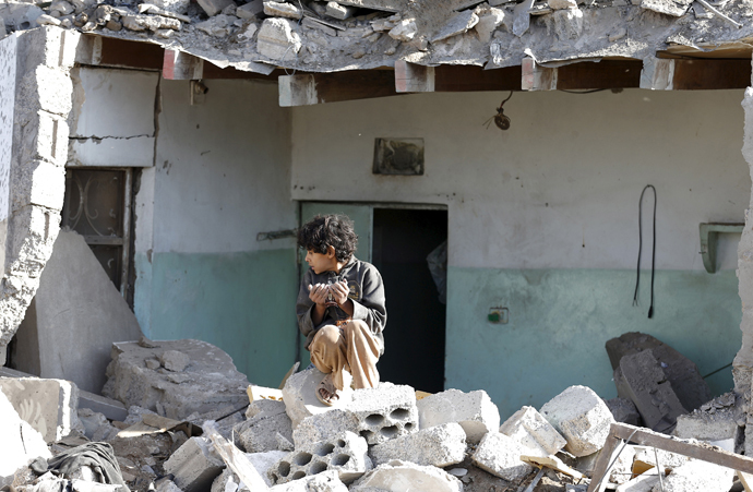 A boy sits at the site of an air strike at a residential area near Sanaa Airport March 26, 2015. (Reuters / Khaled Abdullah)
