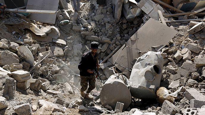 A police trooper walks in a creater caused by an air strike on houses near Sanaa Airport March 31, 2015 (Reuters / Khaled Abdullah)
