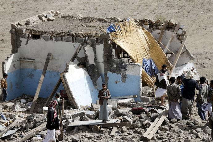 People gather on the wreckage of a house destroyed by an air strike in the Bait Rejal village west of Yemen's capital Sanaa April 7, 2015. (Reuters/Khaled Abdullah)