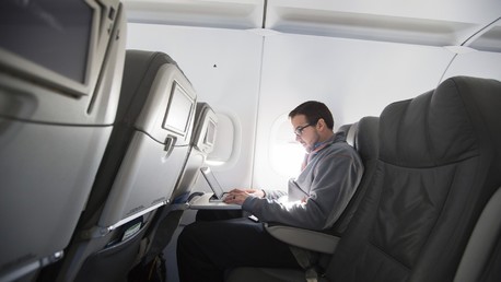 Un homme utilise son ordinateur portable en vol