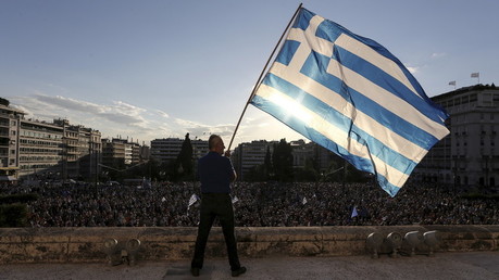 Un manifestant brandit le drapeau national grec 