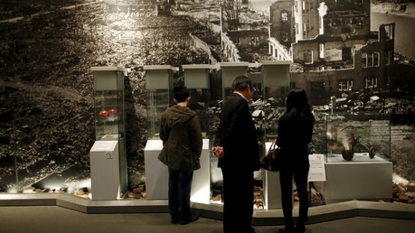 Des visiteurs devant une image avec Hiroshima après les bombardements en 1945