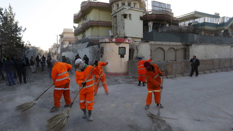 Des agents municipaux nettoient la route après l'attentat à proximité de l'ambassade d'Espagne à Kaboul