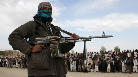 
Combattant taliban derrière une foule venue assister en avril 2015 à l'exécution de trois hommes accusées d'avoir tués un couple au moment d'un vol dans la province de Ghazni 