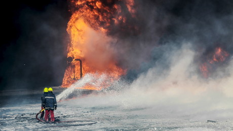 Les pompiers travaillent à éteindre l'incendie sur un des containers de pétrole à Ras Lanouf, en Libye