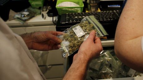 Un client tient un sachet de cannabis médical dans un magasin de Safed, en Israël 