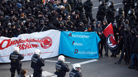 Des manifestants tiennent une bannière parodique Arschloecher feiern Deutschland (qui peut se traduire par 