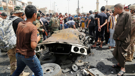 Des habitants de Bagdad sur les lieux d'un attentat à la voiture piégée dans un quartier chiite de la ville, le 11 mai 2016