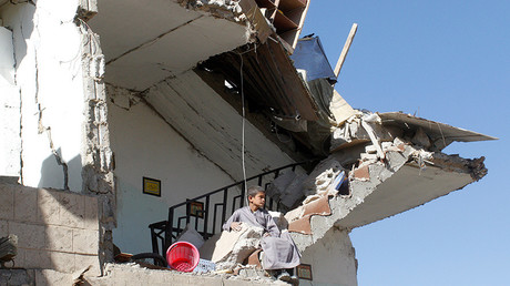Un enfant assis dans les décombres d'une maison détruite à Sanaa par des frappes aériennes de la coalition militaire dirigée par l'Arabie saoudite 