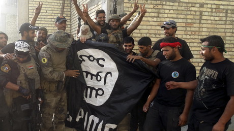 Des militaires irakiens avec un drapeau de Daesh dans la ville de Ramadi libérée de terroristes, juillet 2015