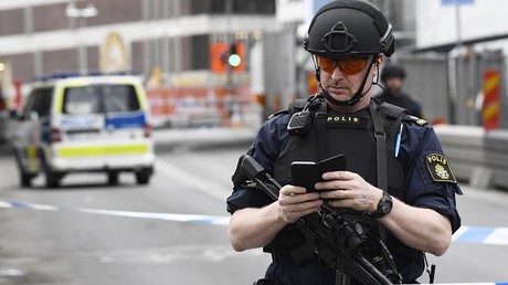 Un policier vérifie son téléphone après l'attaque de Stockholm