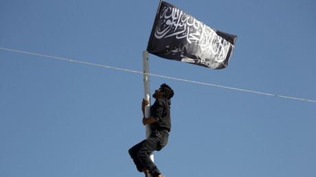 Un djihadiste venant de placer un drapeau d'al-Nosra