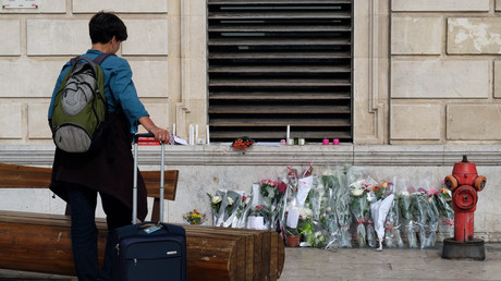 Une personne se recueille devant le mémorial improvisé dédié aux deux victimes de l'attentat de Marseille, face à la gare Saint-Charles.
