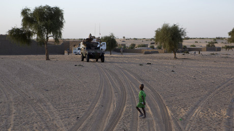 Un enfant traverse devant un convoi militaire de l'opération Barkhane, près de Tombouctou