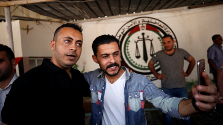 Un Palestinien prend un selfie avec un membre du mouvement du Fatah lors de sa libération d'une prison dirigée par le Hamas dans le cadre des efforts de réconciliation dans la ville de Gaza le 1er octobre 2017