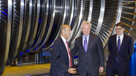 Patrick Kron, PDG d'Alstom (droite) et Jeffrey R. Immelt (centre), PDG de General Electric en 2014,  posent devant une turbine Alstom, photo ©SEBASTIEN BOZON / AFP