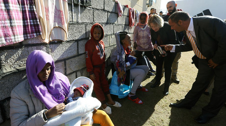 Bettina Muscheidt (au centre de la photo), ambassadrice et responsable de la délégation de l'Union européenne en Libye, parle à un migrant africain en visitant le centre de détention de Tariq Al-Matar en Libye