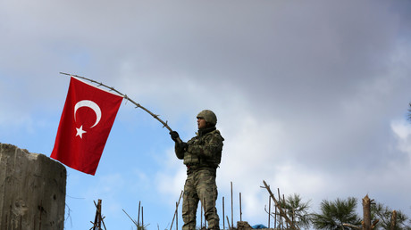 Un soldat turc agitant un drapeau près d'Afrin