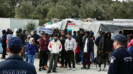 Policiers montant la garde près de migrants au camp de Moria sur l'île de Lesbos, un an après l'accord entre l'Union européenne et la Turquie. A la suite de la fermeture des frontières, 15 000 migrants sont confinés dans les îles grecques.
